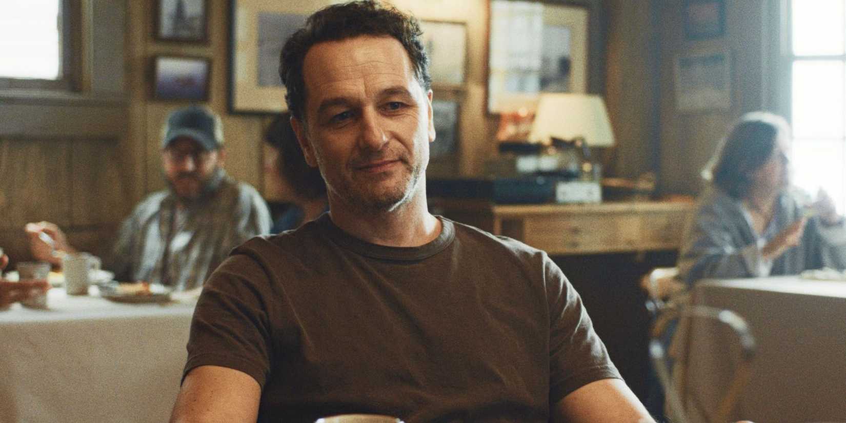 Matthew Rhys sitting in a restaurant in 'Widow's Bay'