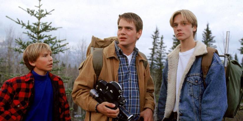 Jonathan Taylor Thomas, Devon Sawa, and Scott Bairstow as the Stouffer brothers holding a camera in the wilderness in Wild America