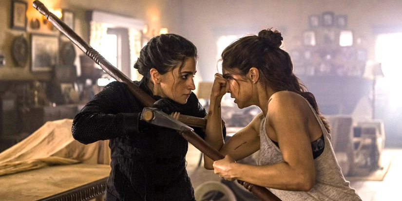 Two women fight each other with an axe and a pole