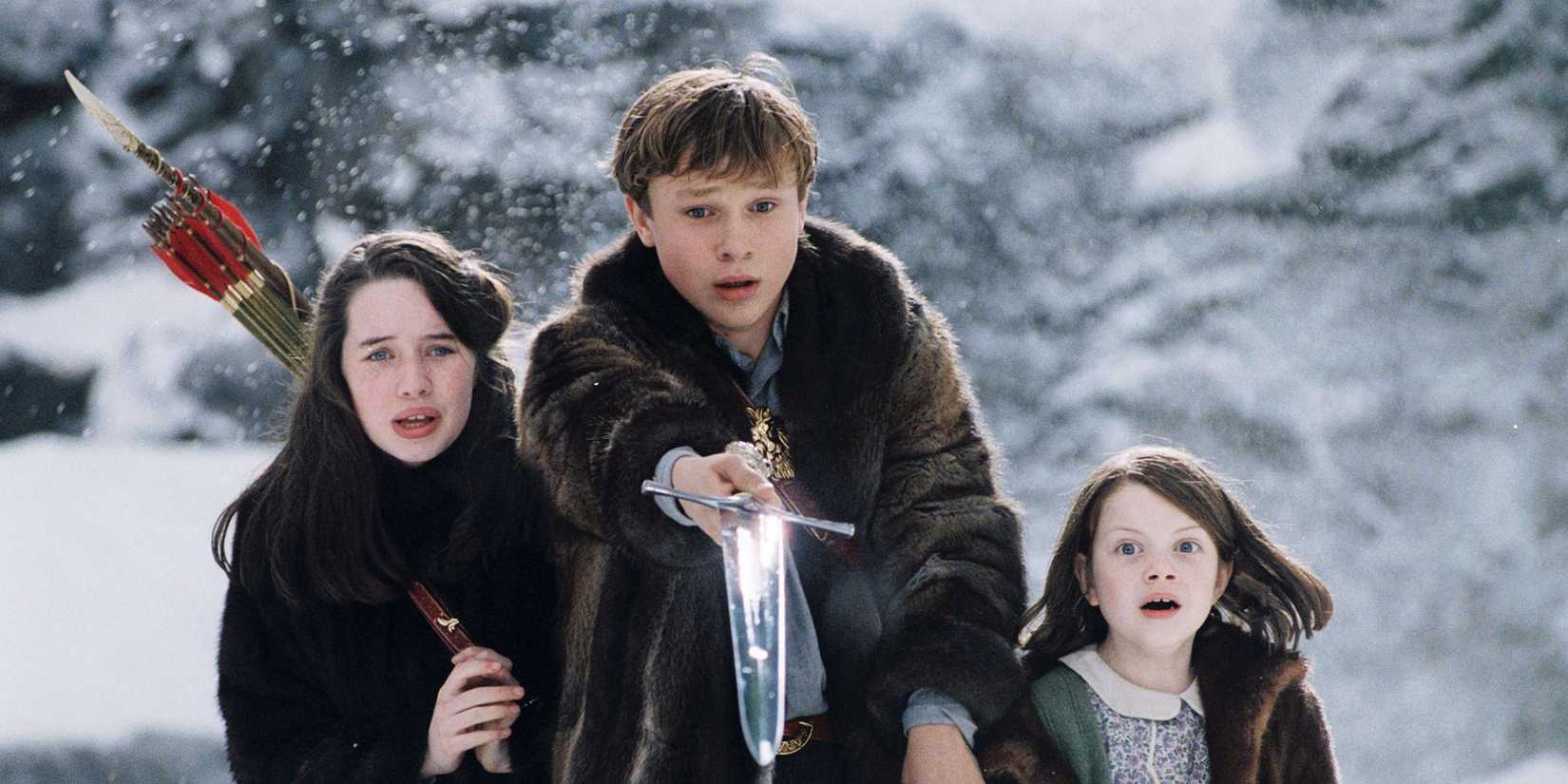 William Mosely holding out a sword alongside Anna Popplewell and Georgie Hensley in The Chronicles of Narnia
