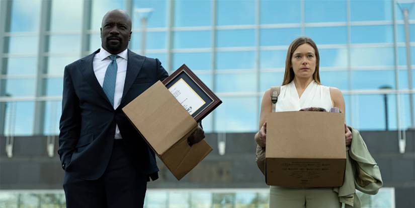A man and a woman standing outside an office holding boxes of their things in Cupertino.