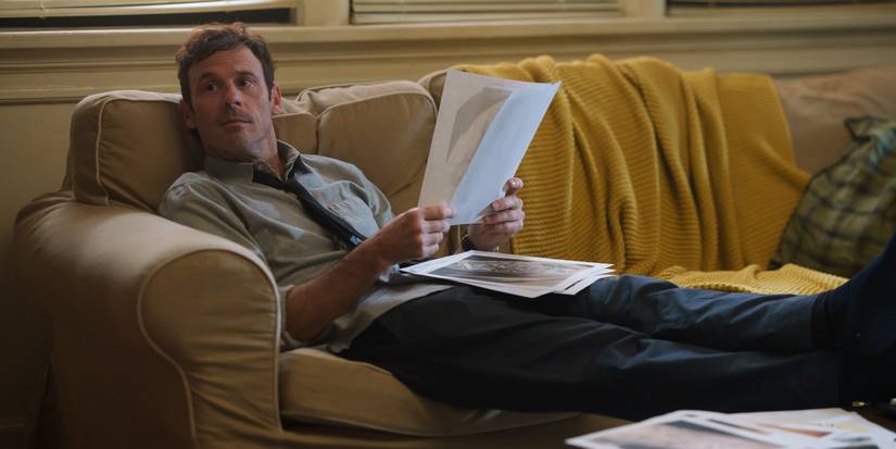 Danny (Scoot McNairy) reclining on a couch, looking at papers, in Furious Episode 2