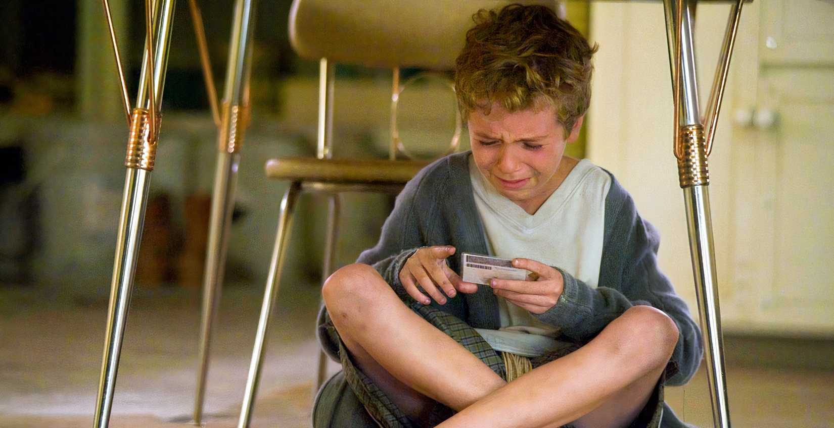 a little boy cries under a table in the thriller Chained (2012) 