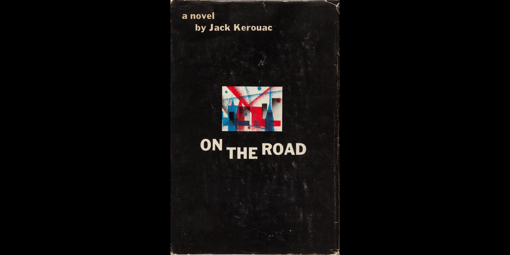 Book cover of On the Road by Jack Kerouac, featuring a mostly black background with a small abstract red, blue, and white illustration in the center and the title in bold white lettering.