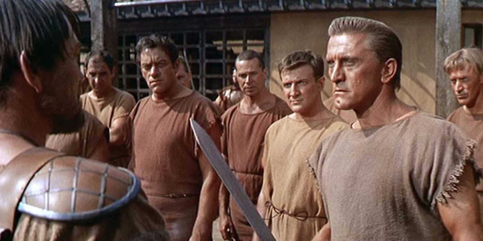 Kirk Douglas holding a sword with men beside him in 'Spartacus'