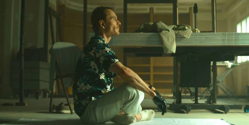 Michael Fassbender sitting on the ground in 'The Killer'