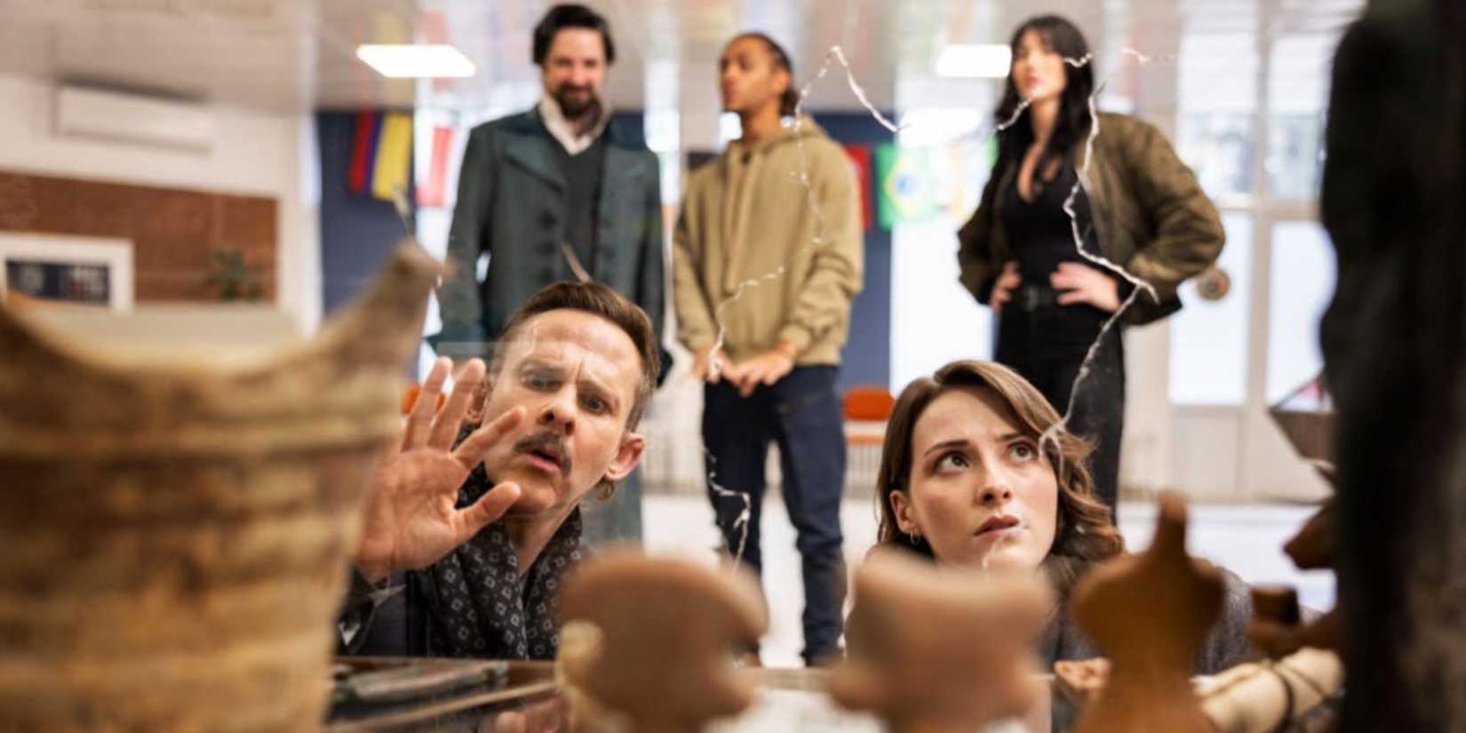 Merlin (Dominic Monaghan) and Lysa Pascal (Olivia Morris) examine artifacts while Vikram Chamberlain (Callum McGowan), Connor Green (Bluey Robinson), and Charlie Cornwall (Jessica Green) stand behind them on 'The Librarians: The Next Chapter'