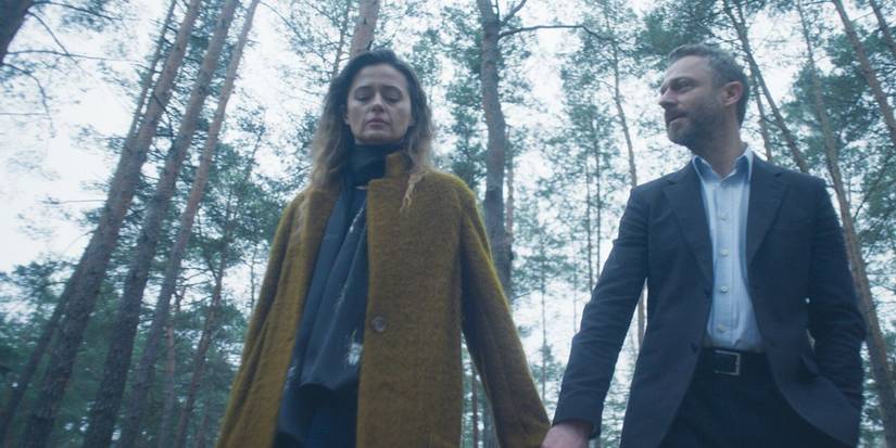 A woman and a man holding hands in the Harlan Coben miniseries 'The Woods'