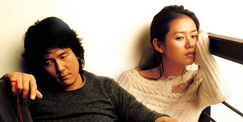 Kam Woo-sung and Son Ye-jin sitting pensively in a scene from the drama series Alone in Love