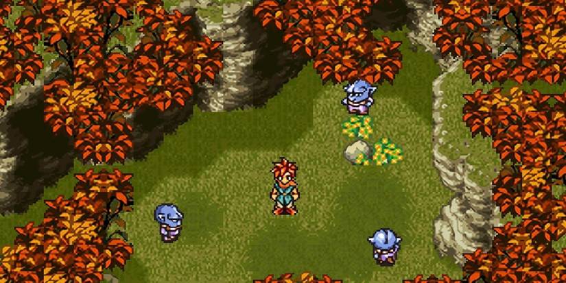 A spiky-haired character stands in a forest surrounded by three small blue monsters, in Chrono Trigger game
