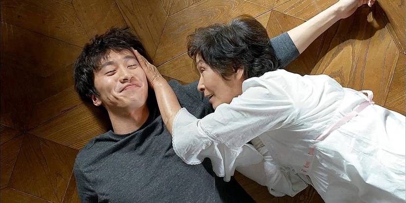 Actors Jo In-sung and Kim Hye-ja lying together on a wooden floor in a touching scene from Dear My Friends