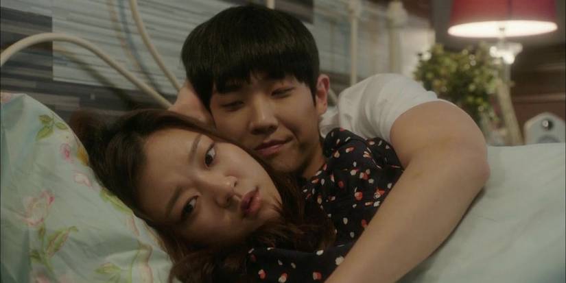 A couple laying in bed together in 'Heard It Through the Grapevine'