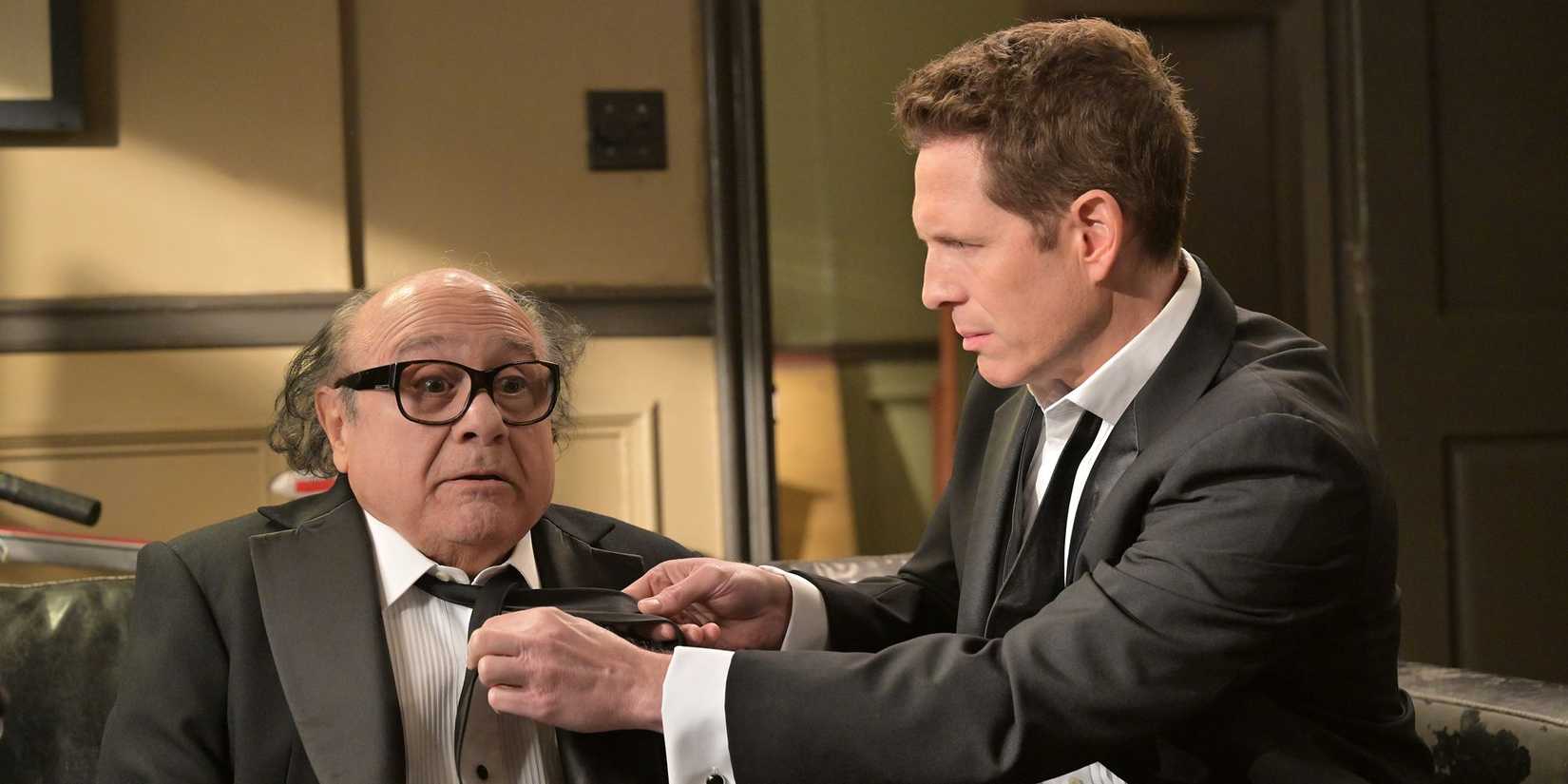 Dennis (Glenn Howerton) helps Frank (Danny DeVito) with his tie in 'It's Always Sunny in Philadelphia' Season 18.