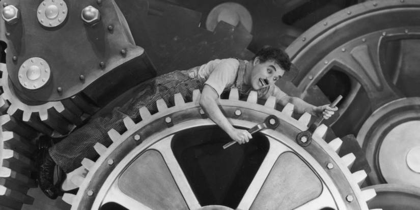 Charlie Chaplin as A Factory Worker turning bolts on a large gear in Modern Times