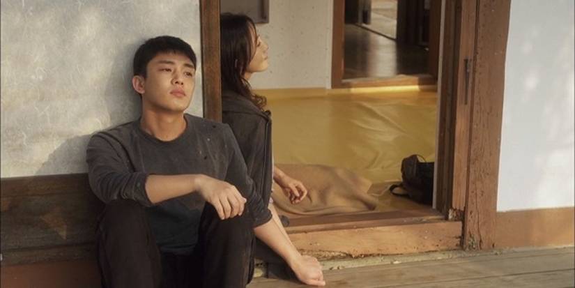 Two characters on opposite sides of a door frame holding hands in the K-drama 'Secret Love Affair'