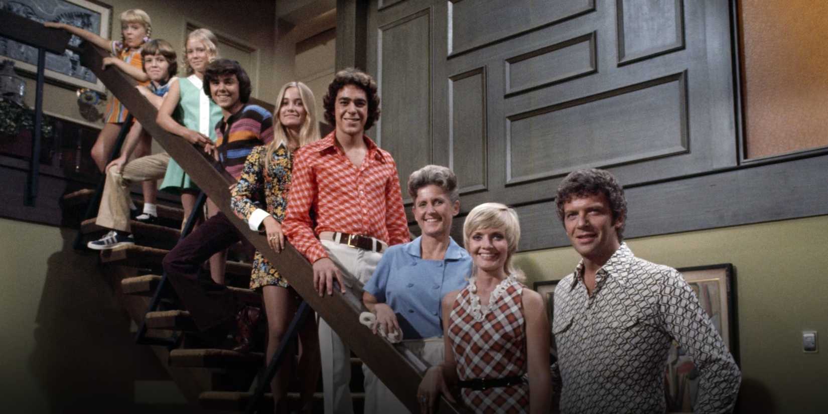 Promotional image of the Brady Bunch cast standing on the staircase.
