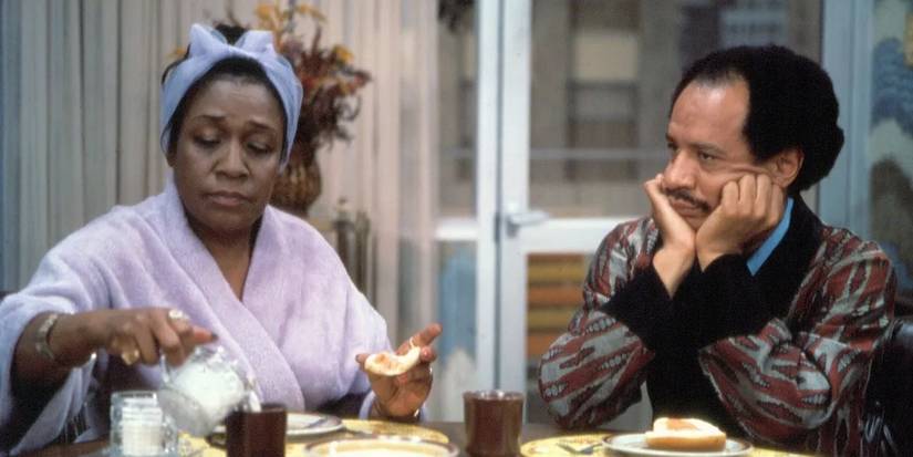 Sherman Hemsley and Isabel Sanford as George and Louise sitting at the table in 'The Jeffersons' pilot episode. 