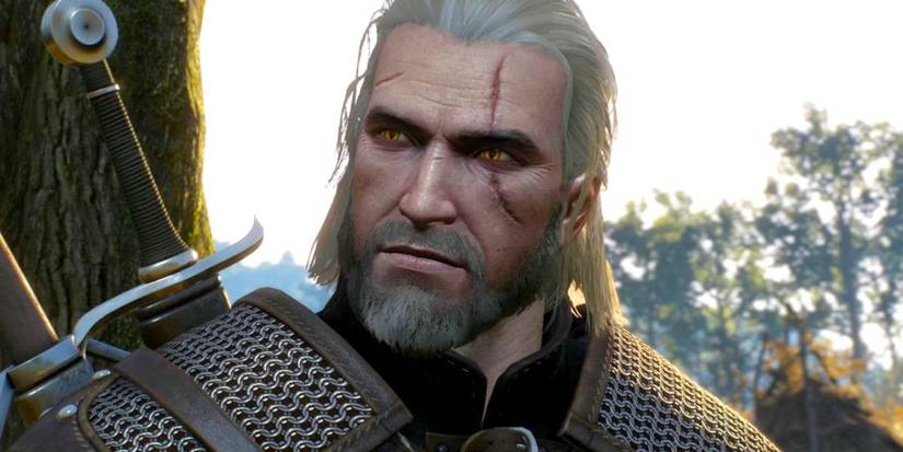 Scarred monster hunter Geralt of Rivera stands against a tree on a sunlit day with his sword holstered over his shoulder in 'The Witcher 3: Wild Hunt' (2015).