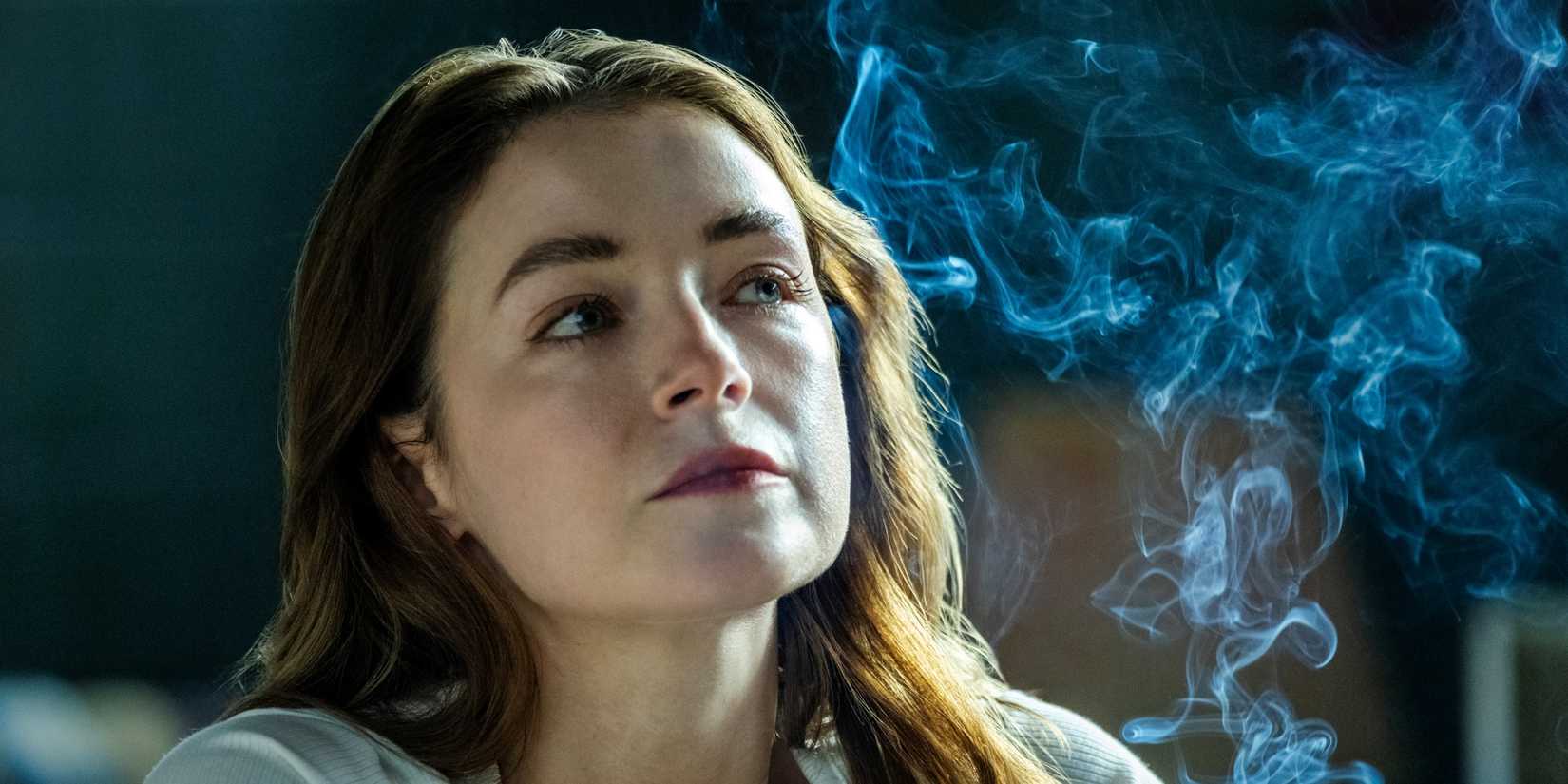Sarah Bolger as Bridget Walsh sitting next to a cloud of cigarette smoke in The Westies 