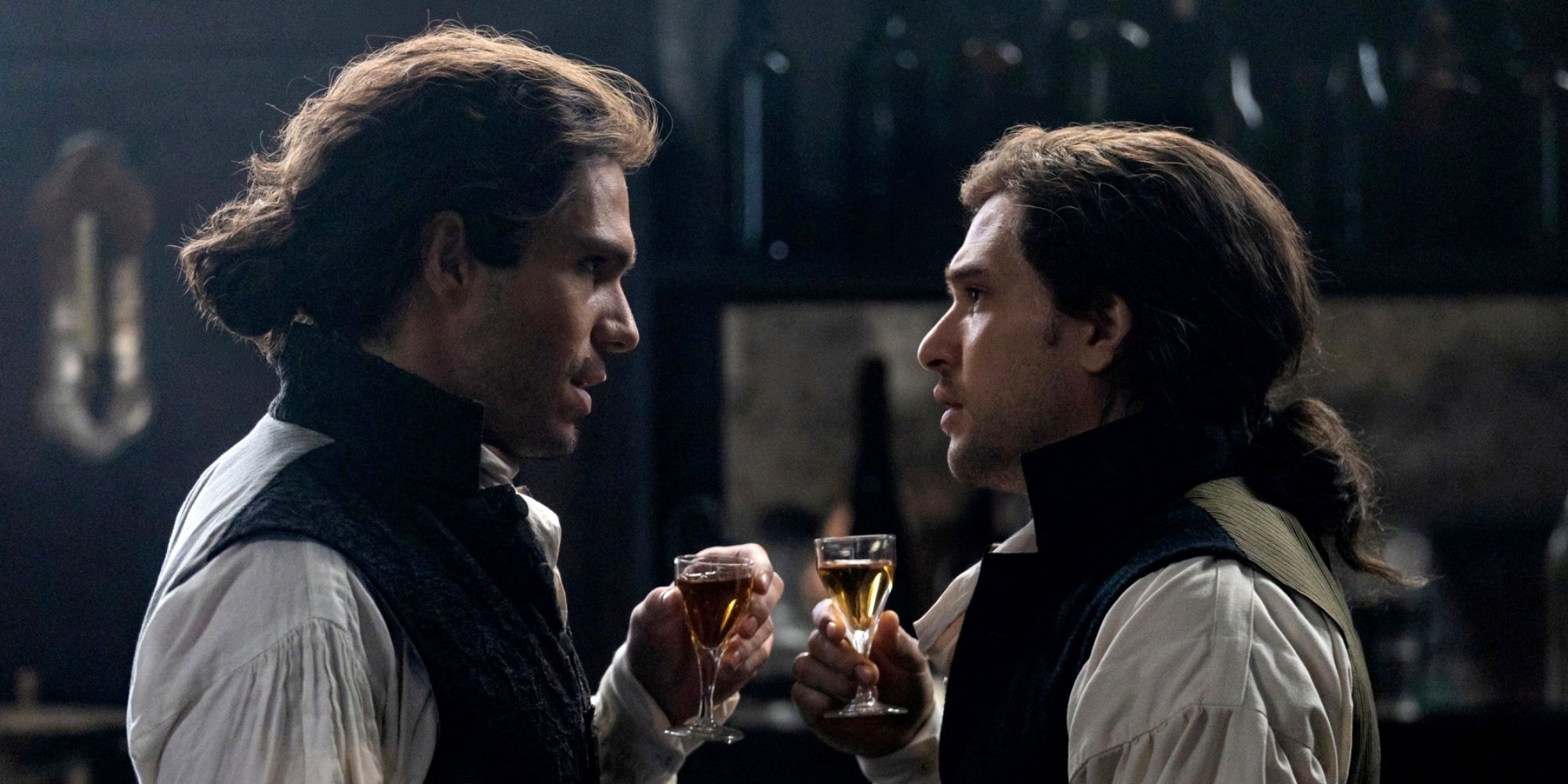 François Civil as Charles Darnay standing in a bar with Kit Harington as Sydney Carton in A Tale of Two Cities