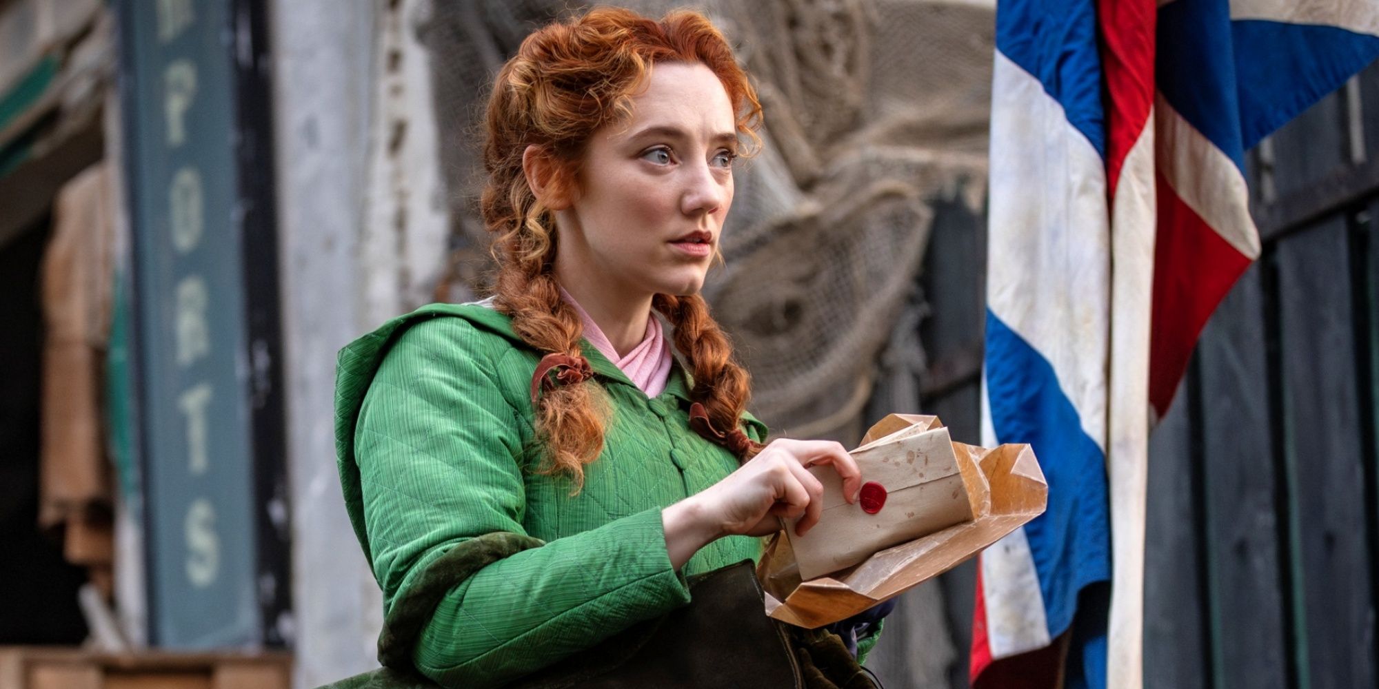 Mirren Mack as Lucie Manette looking up at someone while holding a letter in A Tale of Two Cities