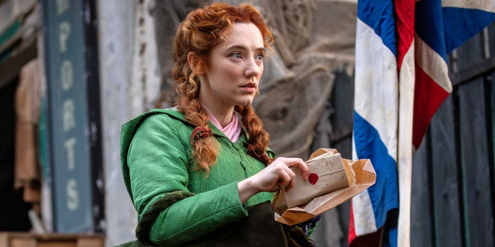 Mirren Mack as Lucie Manette looking up at someone while holding a letter in A Tale of Two Cities