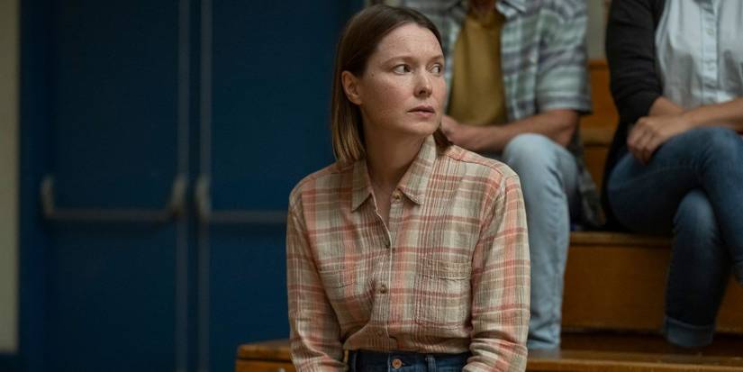 Samantha Sloyan as Margaret White sitting in a school gymnasium in Carrie.