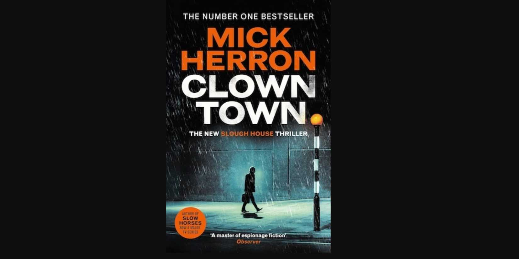A man walking in a neon rain-soaked street on the cover of Clown Town