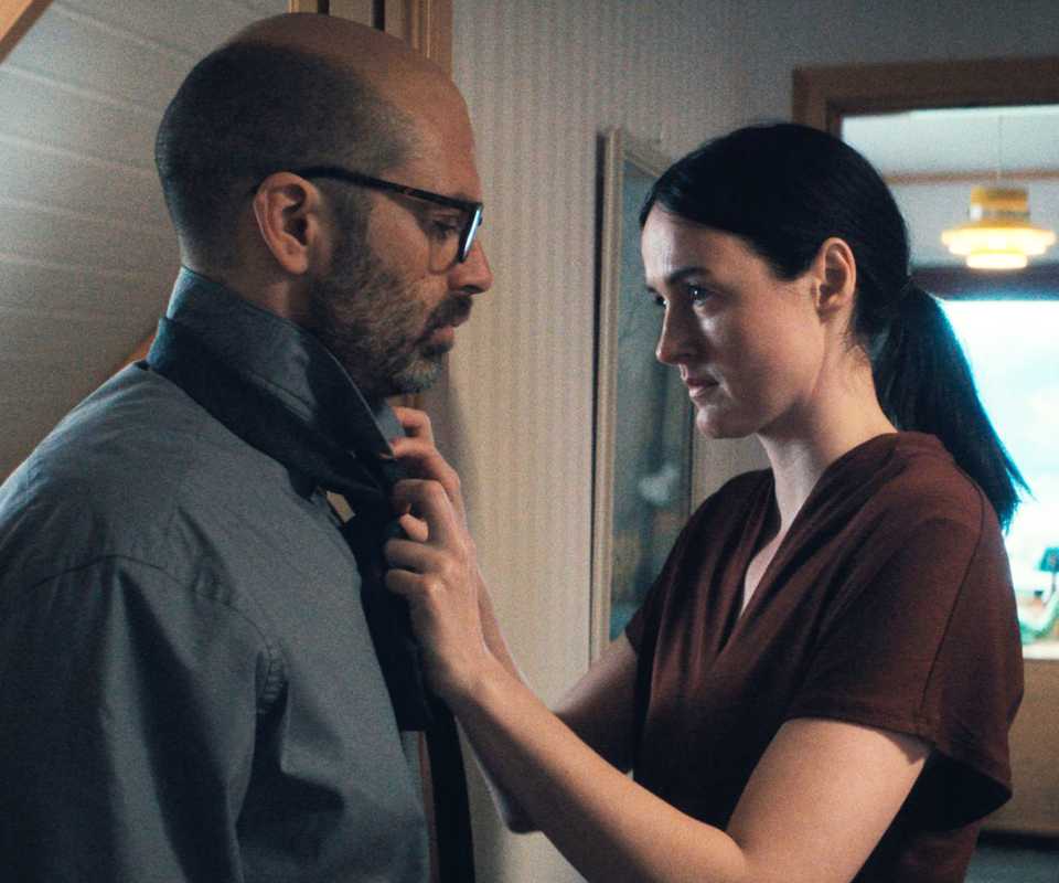A woman straightens a man's tie.