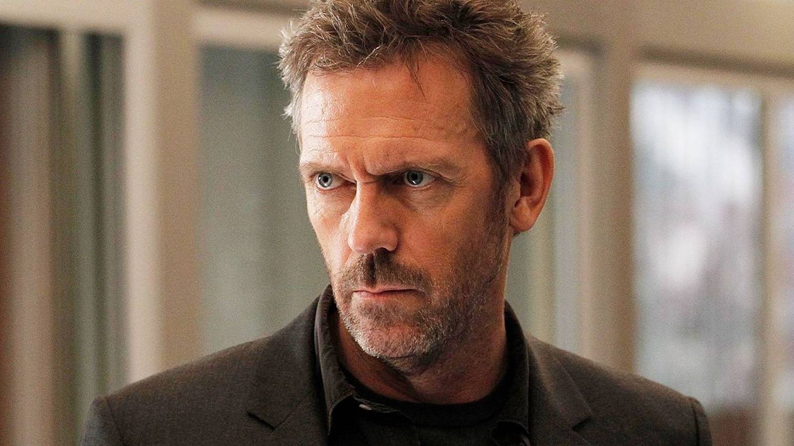 Hugh Laurie looking to the side with a serious expression in House