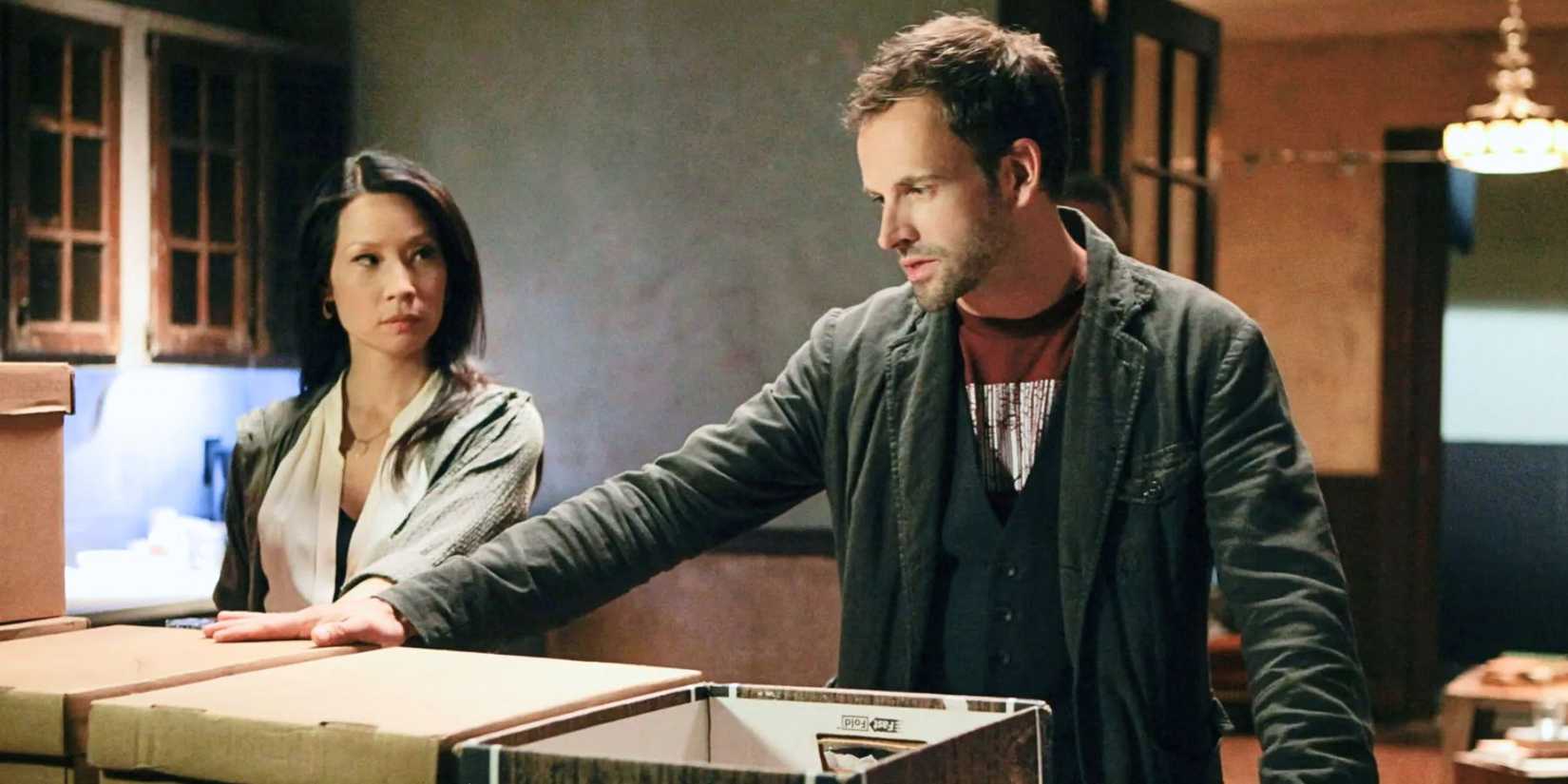 Lucy Liu looking at Jonny Lee Miller standing next to her in Elementary (2012-2019)