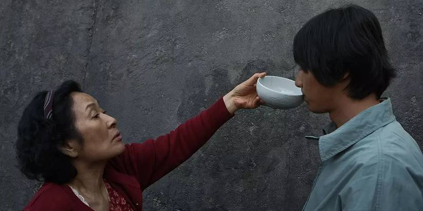 Mother (Kim Hye-ja) feeds her son Do-joon (Won Bin) in Mother (2009).