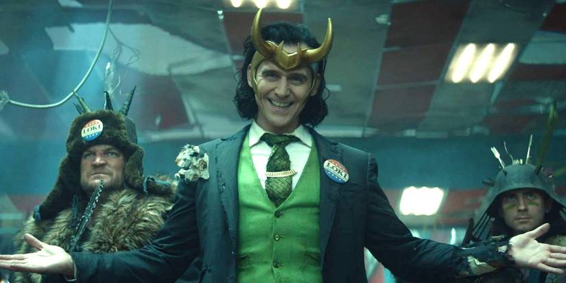 Tom Hiddleston as President Loki wearing a campaign button and smiling in Loki TV series