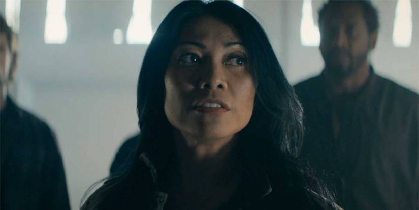 Amisha glaring at someone with others in the background in Reacher.