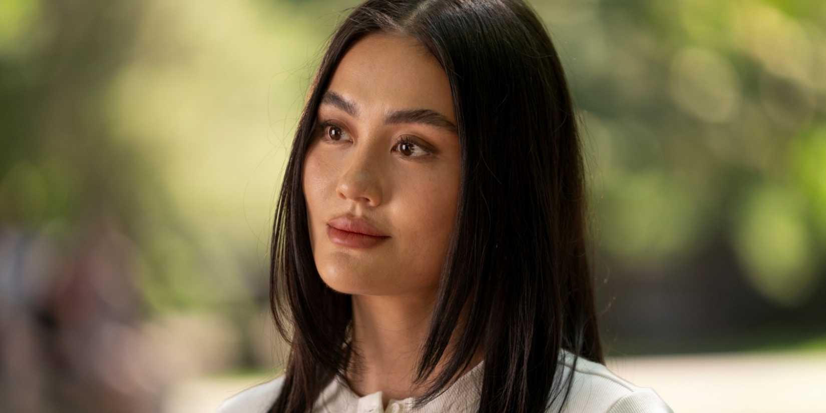 Agnez Mo as Lila Hoth sitting on a park bench while looking serious in Reacher Season 4