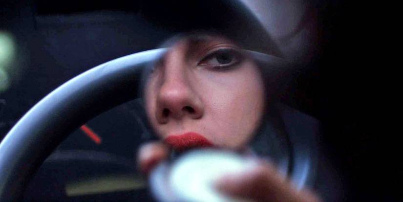 Scarlett Johansson in Under The Skin looks at herself in a small compact mirror