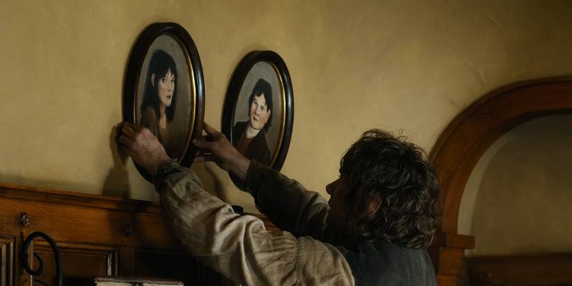 Bilbo Baggins hanging the portraits of his parents on the wall at Bag End