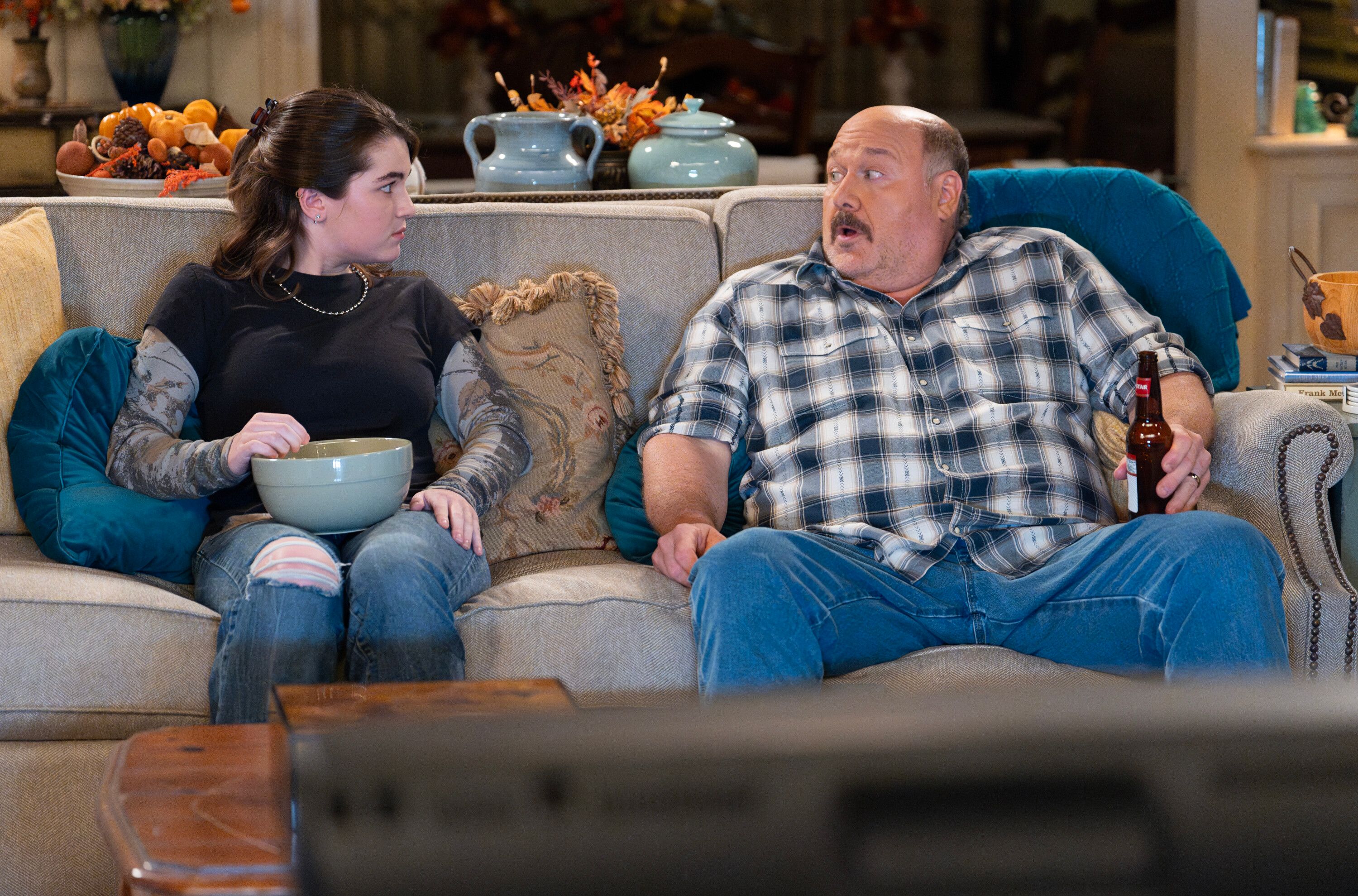 Raegan Revord sitting on the couch with Will Sasso in Georgie & Mandy's First Marriage Season 3