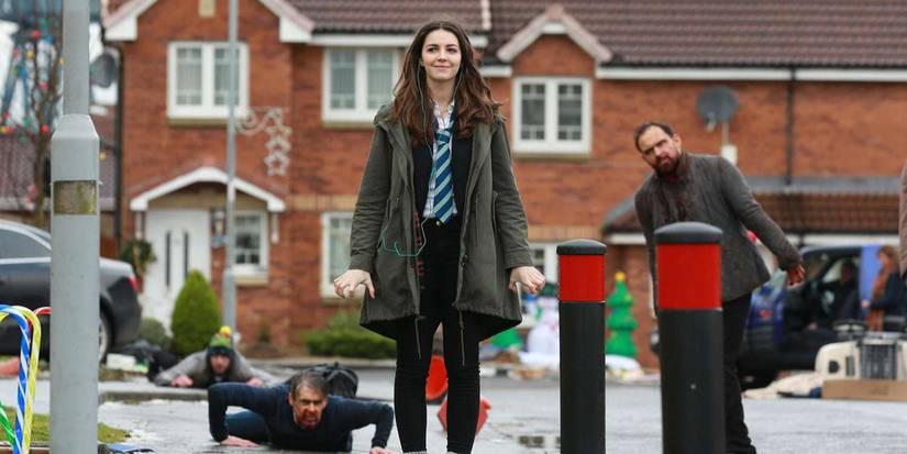 Anna walking down the street with zombies behind her in 'Anna and the Apocalypse'