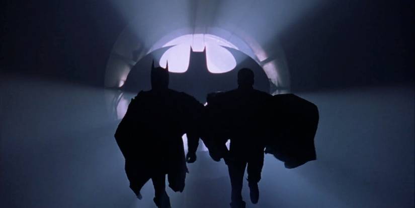 Batman and Robin runnning toward camera in front of Batsignal in 'Batman Forever'