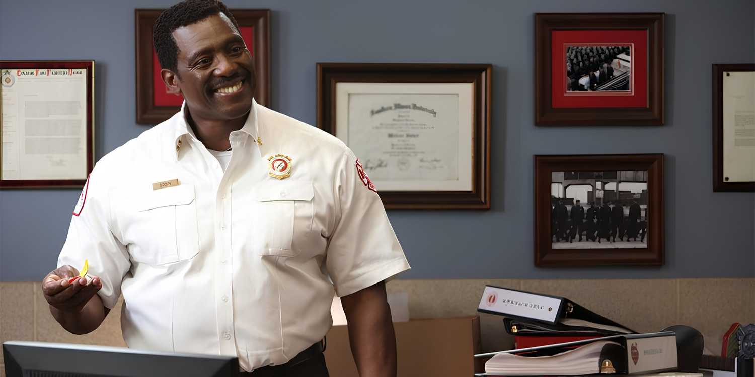 Chief Boden (Eamonn Walker) stands at his desk, smiling, in Chicago Fire.