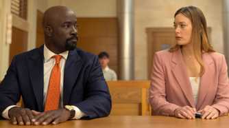 Mike Colter as Michael Price sitting next to Rachel Keller as Olivia Siffre in court in Cupertino