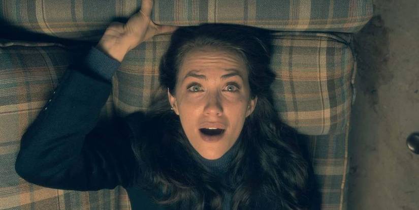 Theo (Katie Siegel) laying on her couch looking scared in 'The Haunting of Hill House'