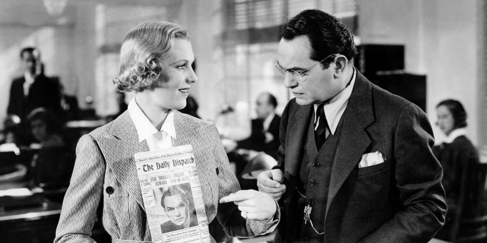 Jean Arthur holding a newspaper while standing next to Edward G. Robinson in The Whole Town's Talking (1935)