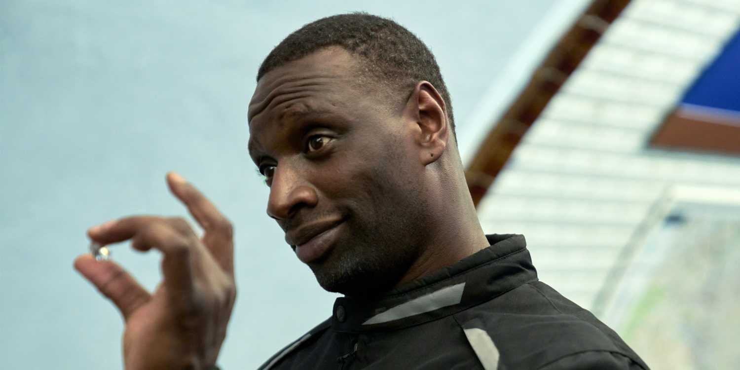 Omar Sy as Assane Diop holding a diamond in front of his face in Lupin Season 4