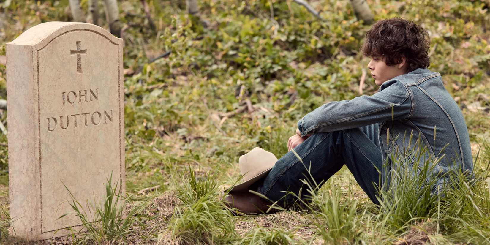 Brecken Merrill as Tate sitting on the grass and looking at John Dutton's grave in Marshals Season 2
