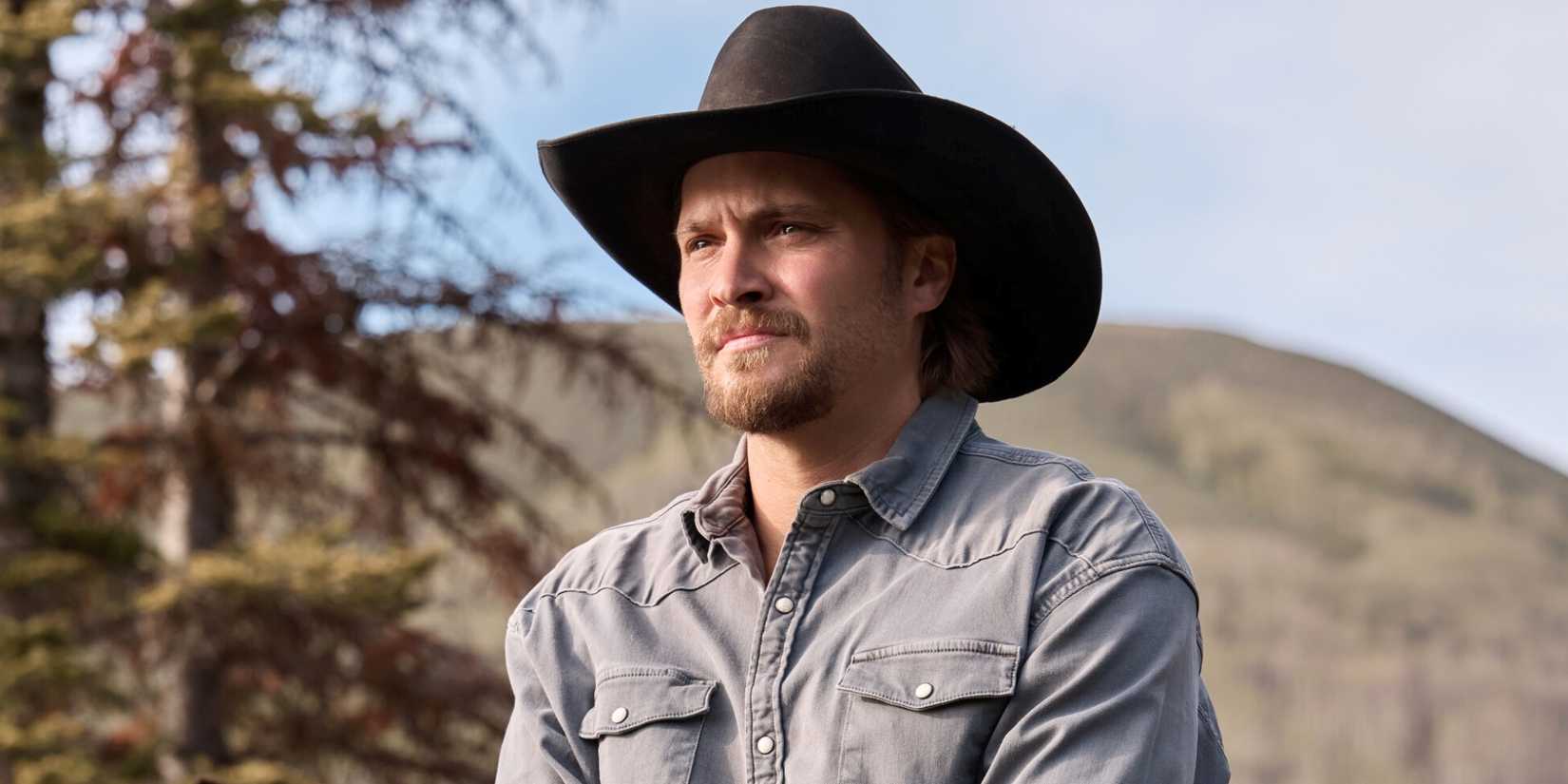 Luke Grimes as Kayce Dutton in a cowboy hat while taking in his surroundings outside in Marshals Season 2