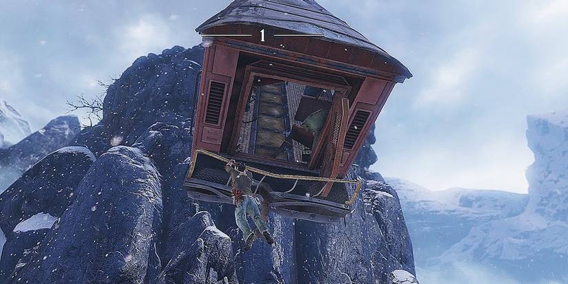Nathan Drake hanging off a train in 'Uncharted 2 Among Thieves'
