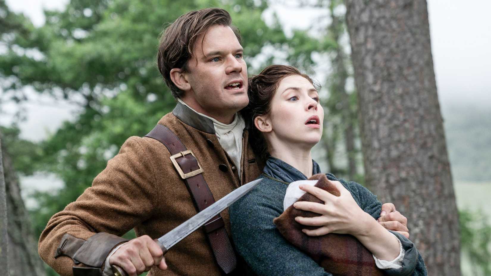 Jeremy Irvine as Henry holding a sword to Hermione Corfield as Julia in Outlander: Blood of My Blood Season 2