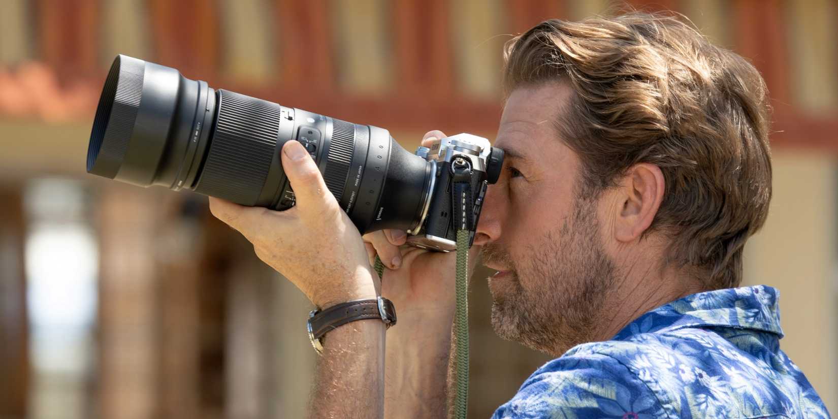 Scott Speedman as R.J. taking a photo with a long lens camera in R.J. Decker Season 2